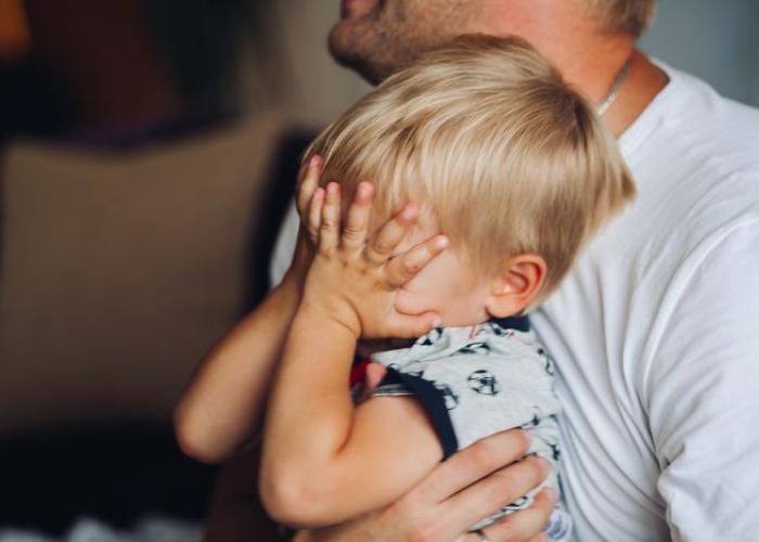 Bébé pleure dans les bras de son papa en voyant arriver la nounou