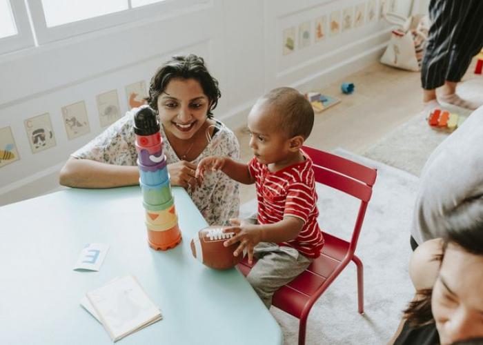 Assistante maternelle jouant avec un enfant dans une crèche