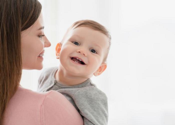 Nounou avec un enfant souriant dans les bras
