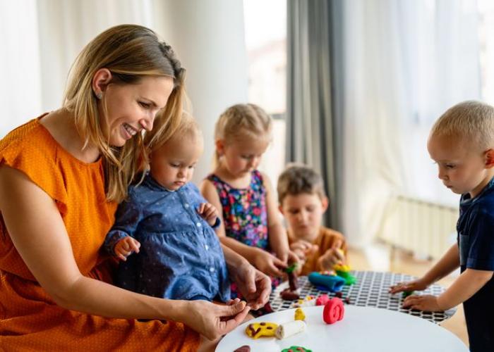 Nounou jouant à la pâte à modeler avec des enfants