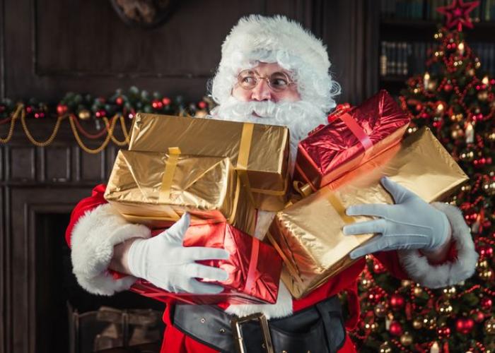 Père Noël avec des cadeaux dans les bras