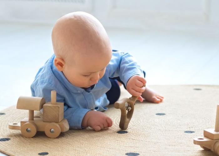 Bébé qui joue avec des jouets en bois et apprend la motricité