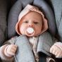 Bébé dans un siège auto avec sa tétine