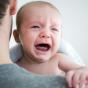 Bébé qui pleure dans les bras de son papa