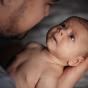 Bébé bien tenu dans les bras de son papa