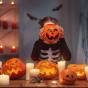 Fillette a une citrouille devant la tête pour fêter Halloween