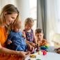 Nounou jouant à la pâte à modeler avec des enfants