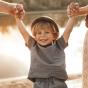 Enfant heureux tenant les mains de ses parents