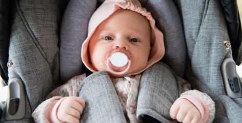 Bébé dans un siège auto avec sa tétine