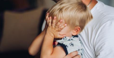 Bébé pleure dans les bras de son papa en voyant arriver la nounou