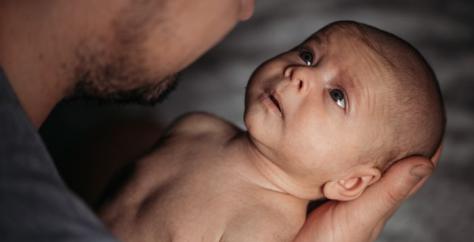 Bébé bien tenu dans les bras de son papa