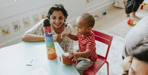 Assistante maternelle jouant avec un enfant dans une crèche