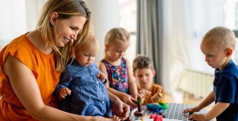 Nounou jouant à la pâte à modeler avec des enfants