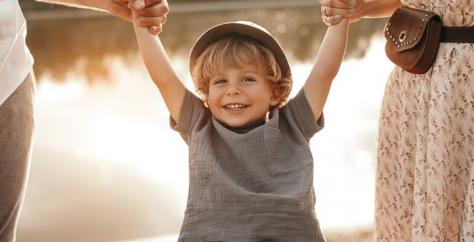 Enfant heureux tenant les mains de ses parents