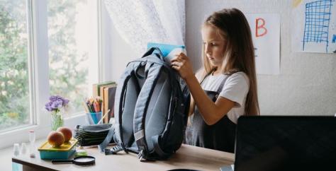 Fillette prépare son sac avant la rentrée des classes