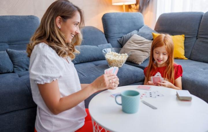 Une maman joue aux cartes avec sa fille